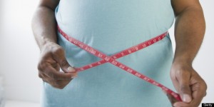 Happy African American man measuring his waistline